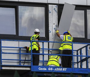 Workers remove cladding from Whitebeam Court, in Pendleton, Manchester, Monday June 26, 2017. The list of high-rise apartment towers in Britain that have failed fire safety tests grew to 60, officials said Sunday, revealing the mounting challenge the government faces in the aftermath of London's Grenfell Tower fire tragedy.