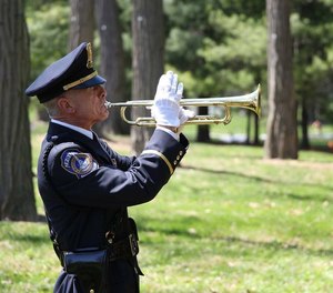 Officer Jeff Stagg plays a bugle for the Honor Guard.