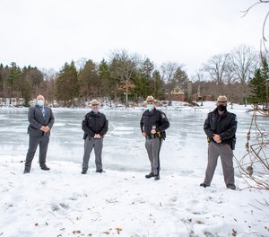 State troopers pose in front of an icy pond after rescuing a fisherman in Wayland, New York.
