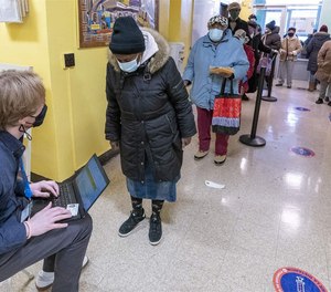 A screener registers residents of a Brooklyn, New York, public housing complex for COVID-19 vaccines. The problems affecting the distribution of vaccines and other parts of the pandemic response reveal the consequences of a decade-long disinvestment of public health in the United States.