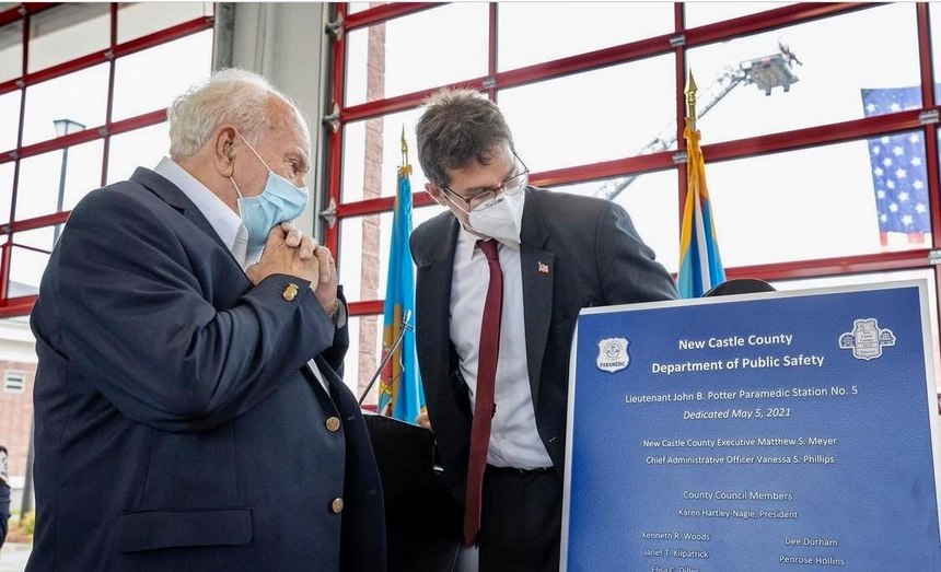 The dedication plaque for "John B. Potter Paramedic Station 5" is unveiled by Potter (left) and New Castle County Executive Matthew Meyer.
