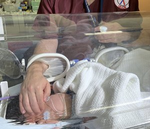 A baby is treated at a hospital after being rescued from a storm drain. (Photo/AP)
