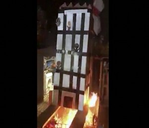 In this grab taken from video, people place a model of Grenfell Towers onto a bonfire in London. (Photo/AP)
