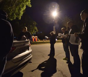 Officers from Fontana PD’s child exploitation team gather at Elmer Digneo Park in Loma Linda at 4:30 a.m. to coordinate before serving a search warrant at the home of a person suspected of collecting and distributing images of child pornography.