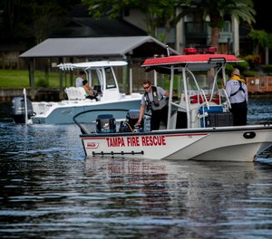 Fire Department rescue team operates a boat in the Hillsborough River near West Columbus Drive in Tampa on Thursday, August 2, 2018.