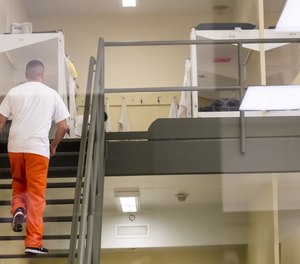 A detainee walks up to his bunk in one of the pods at Northwest ICE Processing Center in Tacoma.