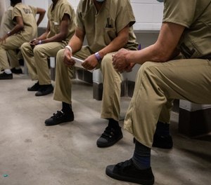 Detainees wait in the intake area before entering to Cermak Health Services for a COVID-19 test and health screening in the Cook County Jail.