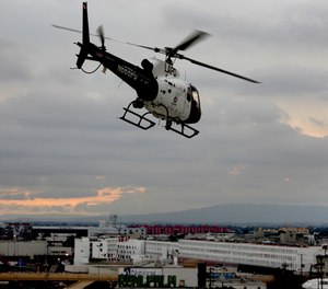 An LAPD helicopter flies over downtown Los Angeles.