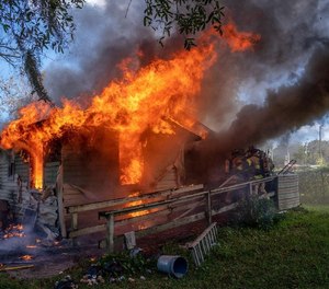Flames erupt from an Acorn Street home as Jacksonville firefighters try to get inside to search for a possible victim. No one was inside, but four firefighters were injured, the fire department said.