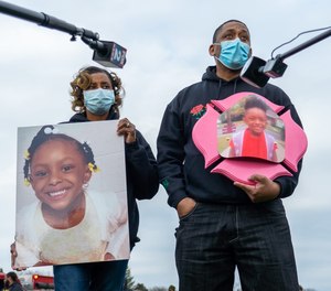 Detroit Police Department Officer LaVondria Herbert and her husband Detroit Firefighter Ebbie Herbert speak with the press after watching a half-mile procession of police, fire and EMS vehicles along Outer Drive in Detroit on April 24, 2020, showing support for the parents who lost their 5-year-old daughter Skylar Herbert to COVID-19. The University of Michigan has debuted the Skylar Herbert Memorial Scholarship which will support the children of first responders.