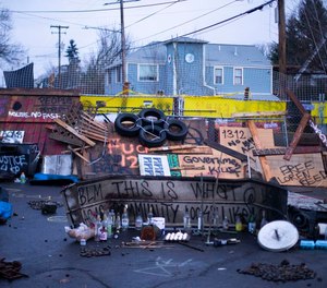 Signs and barricades remain outside a house on North Mississippi Ave. in Portland on December 9, 2020.