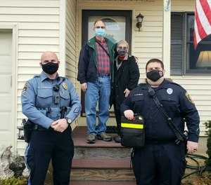 Joe Holler and his wife thank Brick Township Patrolman Daniel Fogarty (left) and EMT Brian Schwarz (right) after they revived him from a