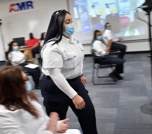 Valedictorian Jazmine Maldonado walks up to accept her EMT training certificate at the graduation of Worcester's first American Medical Response Earn While You Learn student class.