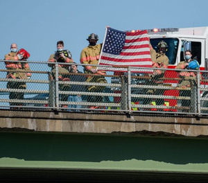 Firefighters stand at attention on a bridge over Interstate 81 near North Syracuse on March 15 as a procession passes below with the body of a Watertown firefighter Peyton Morse.