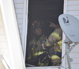Firefighters work at the scene of an apartment fire in Ware, Mass. on Tuesday, March 23. North Brookfield Fire Chief Joseph Holway spotted the fire while off duty and evacuated residents.
