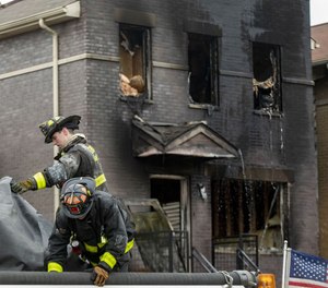 A Chicago firefighter was injured and at least one person was killed in a blaze at a three-story apartment building on Sunday.