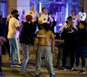 Protesters yell towards the police surrounding Columbus Division of Police headquarters after pepper spray was deployed on a group after they broke a lock and entered the building on April 13, 2021.