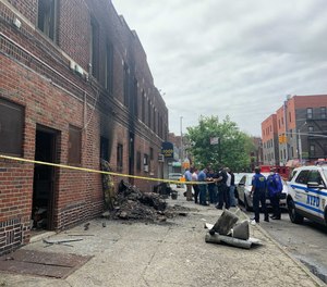 One firefighter and seven tenants were injured, one critically, in a blaze at a two-story brick residential building on Tuesday. A suspect has been charged with assault and reckless endangerment charges for allegedly setting the fire.