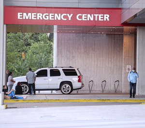 A group of people waits outside of Dell Seton Medical Center waiting for news about victims after a man shot and wounded 14 people at about 1:30 a.m. at the 400 block of 6th street in Austin, Texas on June 12, 2021.