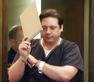 David L. Braden tries to hide his face with a folder as he enters a Franklin County Common Pleas courtroom for his sentencing on June 16, 1999.