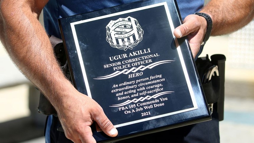 Ugur Akilli holds his HERO award from PBA Local 105.