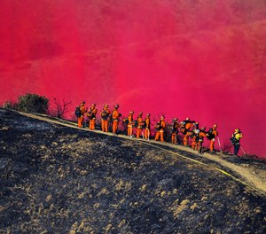 An overnight Cal Fire inmate crew watches as a firefighting plane drops fire retardant along wireline during the October 2020 Bruder fire in Redlands, Califorina.