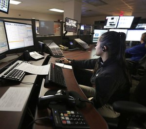 At the Newport News 911 call center, dispatchers give assistance and work at a number of monitors.