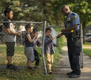 St. Paul police officer Mahamed Dahir stops to talk with some kids and hand out stickers.