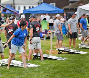 Team members take aim at cornhole boards during a benefit cornhole competition for Braintree K-9 Kitt and officers who were shot in June.
