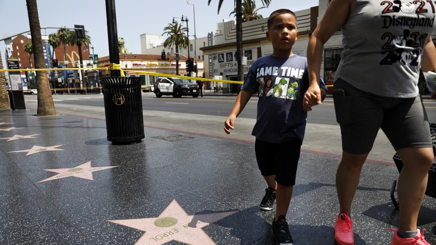 Visitors are turned around at the intersection of Hollywood Boulevard and Highland Avenue while police investigate an officer involved shooting on Thursday, July 15, 2021.