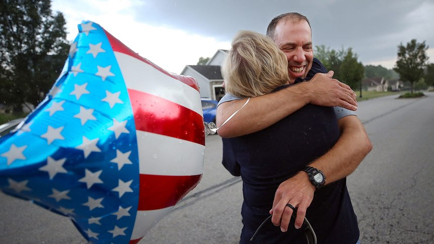 Andy Miller of Ohio Task Force 1 hugs his wife, Jenna Bates, Thursday night when he returned home to Cuyahoga Falls after assisting with recovery efforts at the deadly Florida condo collapse.