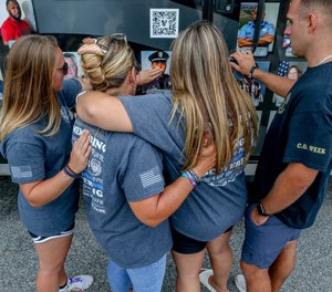 The Freeman family gather to find Russell's picture on the traveling memorial at the Adult Correctional Institutions, part of the National
