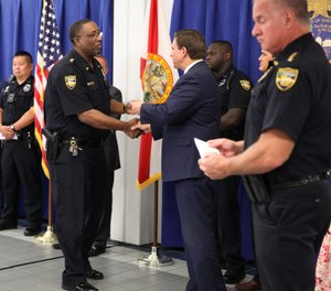 Gov. Ron DeSantis hands out one-time relief checks to first responders at the Jacksonville Sheriff's Office on Aug. 10, 2021.