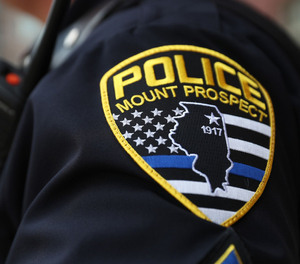 The Mount Prospect police patch is stitched onto the uniform of a sergeant as he guards the entrance to village hall before a meeting of the Village Board to vote on whether or not to change the design of the patch to eliminate the 