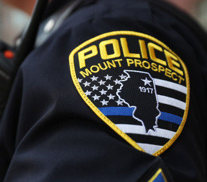 The Mount Prospect police patch is stitched onto the uniform of a sergeant as he guards the entrance to village hall before a meeting of the Village Board to vote on whether or not to change the design of the patch to eliminate the