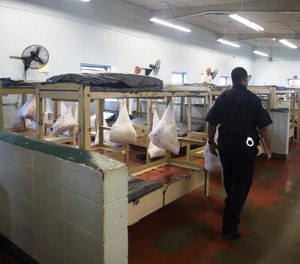 A corrections officer walks through the faith dormitory at Kilby Corrections Facility in Montgomery, Ala., on Friday, Sept. 4, 2015. The facility would be closed under the new prison plan.