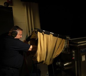 Evidence technician Christopher Lenti test-fires a Glock 9mm at the Chicago police firearms laboratory at the Homan Square police facility on June 9, 2021.
