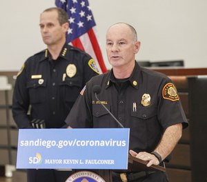 San Diego City Fire Rescue Department chief Colin Stowell (right) speaks to San Diegans during a daily update on the Coronavirus at City Hall on March 20, 2020, in San Diego. In the background is Chief of Police David Nisleit (left).