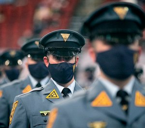 Recruit Scott Livingston, center, sits with other members of his class during a ceremony for the 161st New Jersey State Police Class on March 17, 2021 in Newark, N.J.