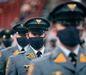 Recruit Scott Livingston, center, sits with other members of his class during a ceremony for the 161st New Jersey State Police Class on March 17, 2021 in Newark, N.J.