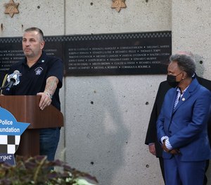 Local FOP President John Catanzara, at podium, appeared with Mayor Lori Lightfoot, right, in September 2021. The pair have commonly lobbed public insults at each other.