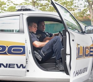 New Haven police officers Frank Grillo, left, and Michael Fumiatti return to the cruiser after a traffic stop.