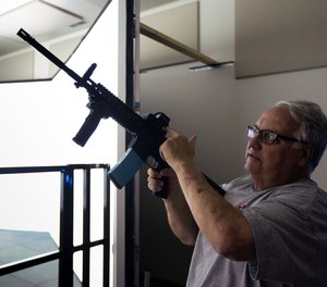 Howard Buffett demonstrates a gun used in a training simulator at the Grant Farm Training Facility, which Buffett helped fund, in Decatur, Ill. on Friday, June 30, 2017.
