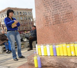 Isabel Gamoneda places candles around monument to Happy Land Social Club fire victims, as her mother, Olga Leticia Gamoneda looks on. They lost two relatives in the horrific Bronx blaxe that killed 87 people.