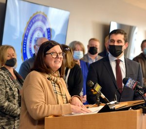 Maureen Moriarty speaks as Hampden district Attorney Anthony Gulluni looks on at a press conference where Gulluni called upon the legislature to amend laws regarding medical parole for first-degree murderers.