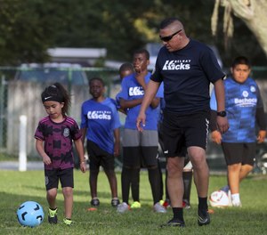 Danny Pacheco, a sergeant with the Delray Beach Police Department, goes through drills with Julian Morales, 6, during soccer practice on March 1, 2022.