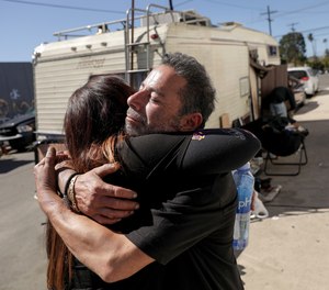 Manny Placeres, 58, right, who has administered naloxone many times, is embraced by registered nurse Linda Leimer, with an L.A. County Department of Health Services medical team.