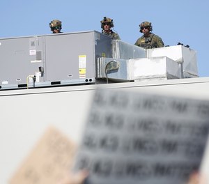 San Diego County deputies stand on a roof above a rally on June 7, 2020.
