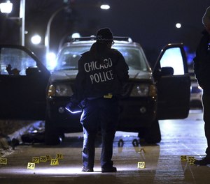 Evidence markers are seen on the ground as Chicago police process a crime scene.