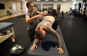 Physical Therapist Alison Heartman (left) works with firefighter Rachel Gregory at the Contra Costa County Fire Protection District Health & Wellness center on March 31 in Pittsburg, Calif. The fitness center offers firefighters a variety of weight and exercise machines along with access to a physical therapist.